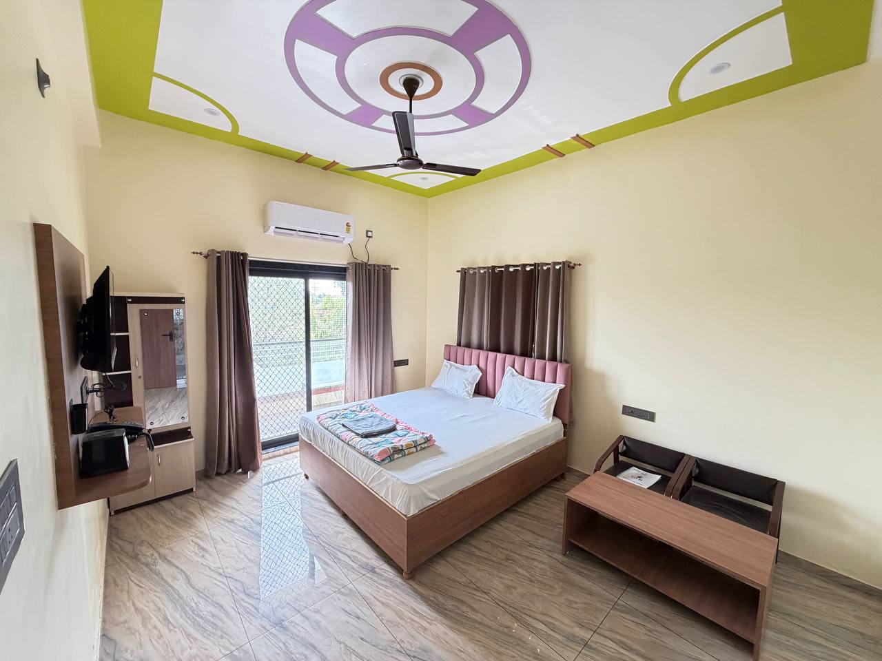Guest bedroom with a glazed balcony door and wooden seating.