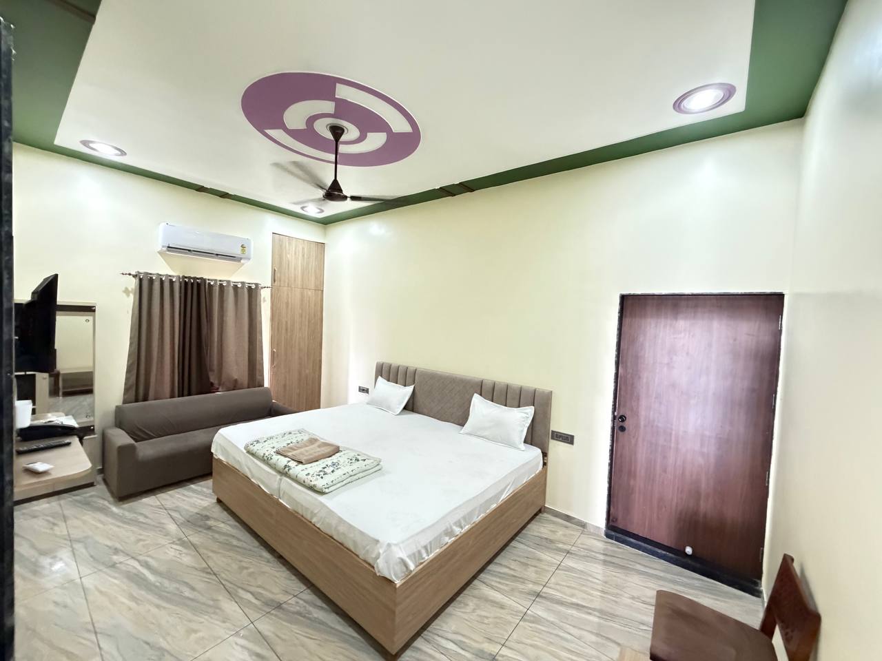 Guest bedroom with a double bed, sofa and decorative ceiling.